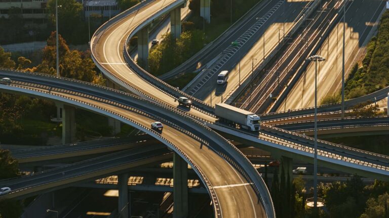 Multi-level freeway interchange with cars and trucks moving across stacked elevated ramps