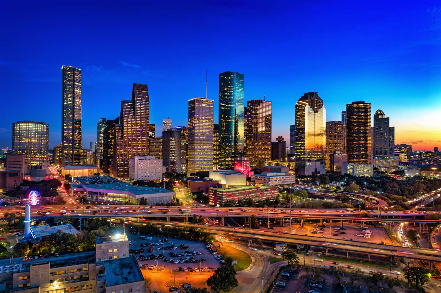 Downtown Houston skyline at dusk with freeway traffic below, the metro area where most Texas rideshare trips begin and end
