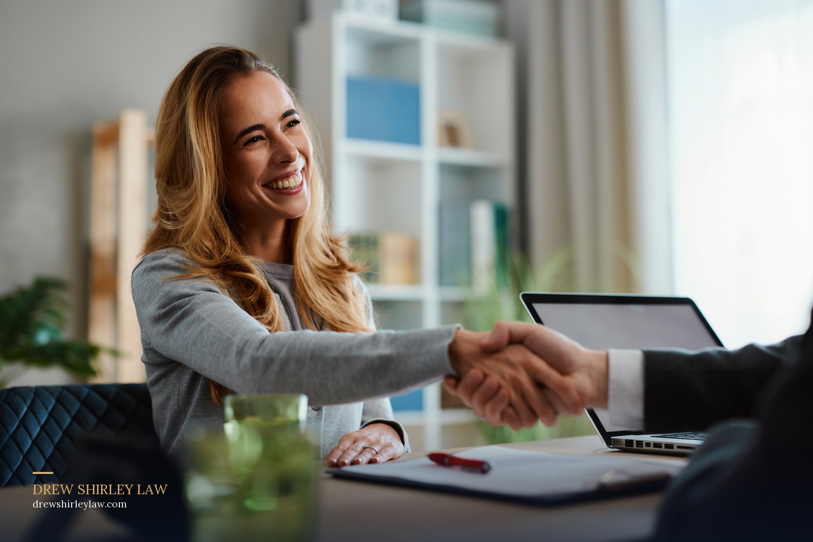 Client shaking hands with her attorney across a desk after resolving a Texas injury claim