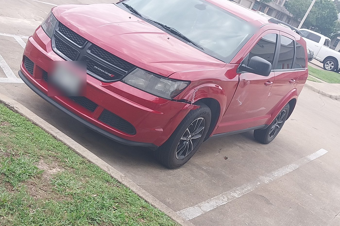 A red SUV in a parking lot with a crumpled front fender and door after a lane-change collision.