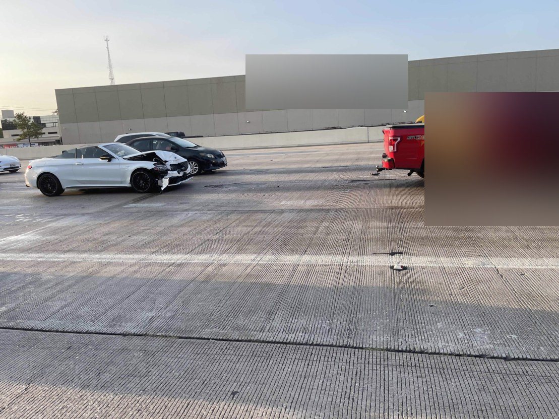 Damaged vehicles stopped on the freeway after a multi-car collision.