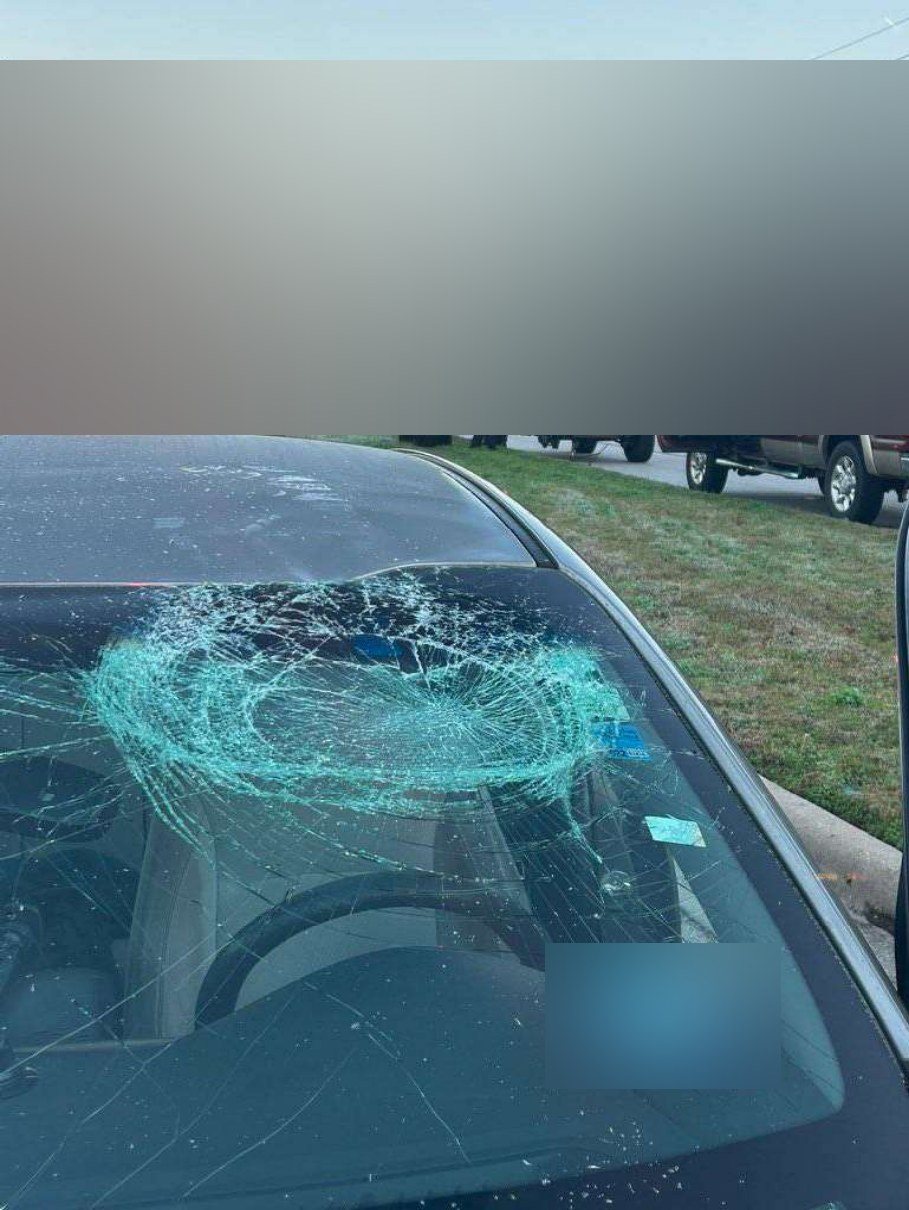 Shattered windshield seen from in front of the car after a wheel came through it.